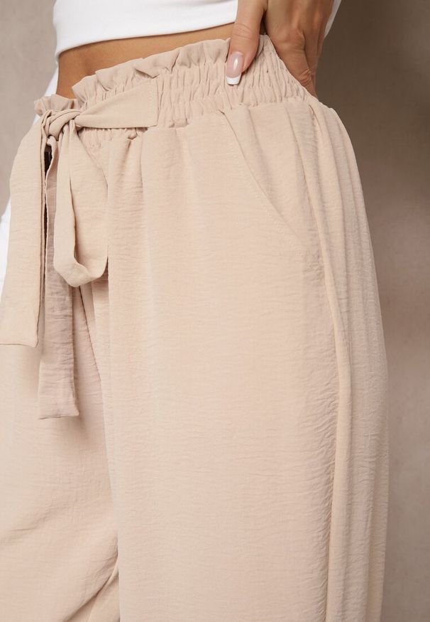 Renee - Beżowe Spodnie High Waist Ozdobione Wiązanym Paskiem Araleira. Okazja: na co dzień, na spacer. Stan: podwyższony. Kolor: beżowy. Materiał: jedwab. Długość: długie. Wzór: aplikacja. Sezon: wiosna. Styl: casual