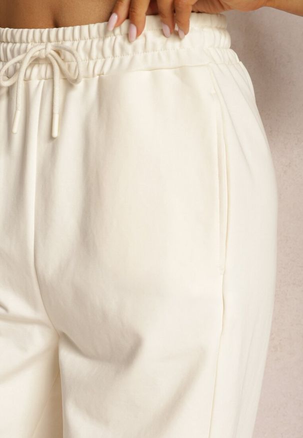 Renee - Jasnobeżowe Dresowe Spodnie High Waist z Gumką w Talii Dimlara. Okazja: na co dzień. Stan: podwyższony. Kolor: beżowy. Materiał: dresówka. Styl: elegancki, casual