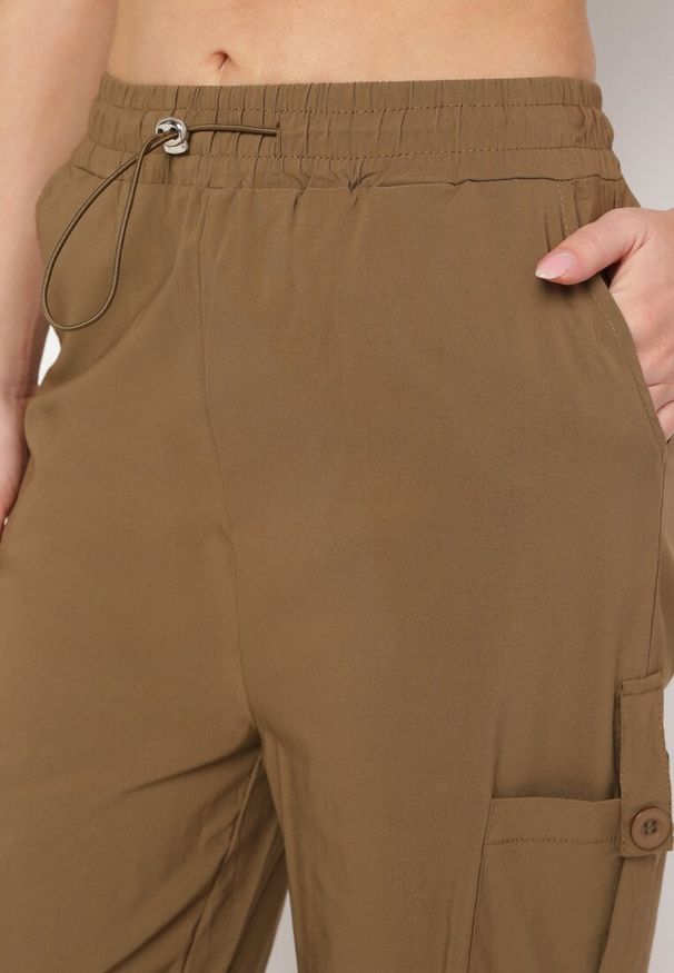 Born2be - Brązowe Spodnie Bojówki z Wysokim Stanem z Gumką w Pasie z Kieszeniami Biorella. Okazja: na co dzień. Stan: podwyższony. Kolor: brązowy. Długość: długie. Styl: elegancki, casual