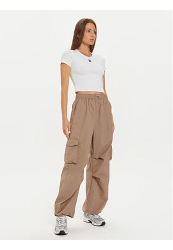 New Balance Spodnie dresowe WP43534 Beżowy Relaxed Fit. Kolor: beżowy. Materiał: syntetyk