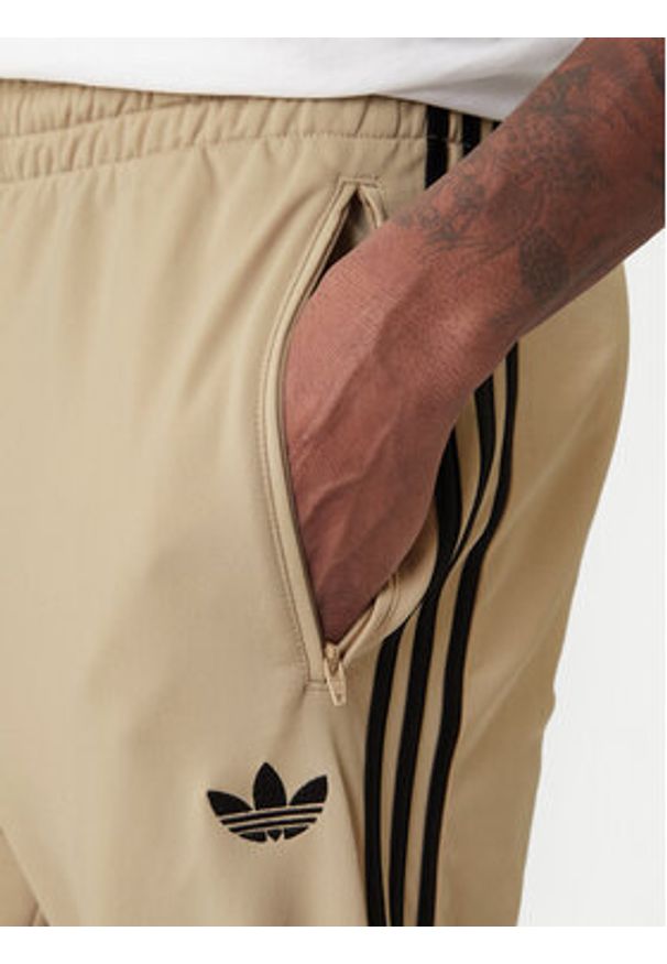 Adidas - adidas Spodnie dresowe Firebird KE6679 Beżowy Loose Fit. Kolor: beżowy. Materiał: syntetyk