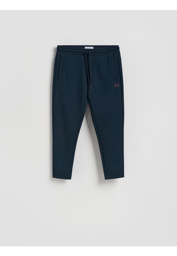 Reserved - Spodnie dresowe slim - granatowy. Kolor: niebieski. Materiał: dresówka
