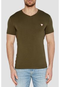 Guess - GUESS Zielony męski t-shirt z małym logo. Okazja: na co dzień. Typ kołnierza: dekolt w serek. Kolor: zielony. Materiał: bawełna, elastan. Długość rękawa: krótki rękaw. Długość: krótkie. Styl: elegancki, klasyczny, casual
