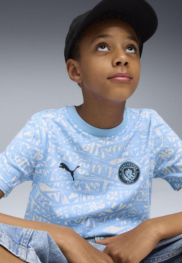 Puma - Młodzieżowa koszulka Manchester City FtblCulture z nadrukiem na całej. Kolor: biały, wielokolorowy, niebieski. Wzór: nadruk