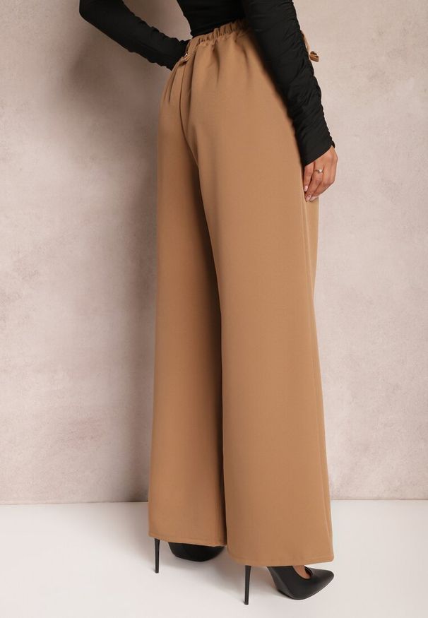 Renee - Brązowe Eleganckie Spodnie Dzwony z Ozdobnymi Patkami w Pasie Nattas. Stan: podwyższony. Kolor: brązowy. Styl: elegancki