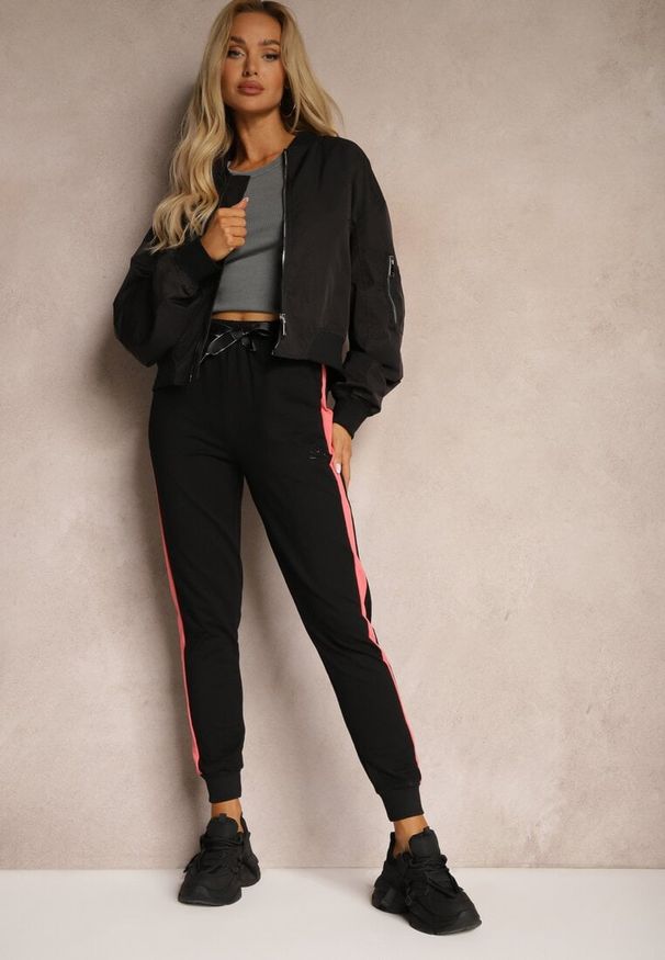 Renee - Czarne Spodnie Dresowe High Waist Wykończone Lampasami i Ozdobione Napisem Sikara. Okazja: na co dzień. Stan: podwyższony. Kolor: czarny. Materiał: dresówka. Długość: krótkie. Wzór: aplikacja, napisy. Styl: sportowy, casual, elegancki