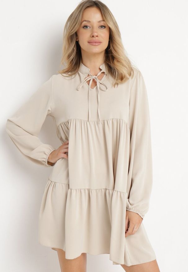 Born2be - Beżowa Rozkloszowana Sukienka z Falbanką Uxaria. Typ kołnierza: kołnierz z falbankami. Kolor: beżowy. Długość rękawa: długi rękaw. Wzór: aplikacja. Styl: elegancki