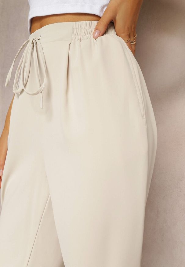 Renee - Beżowe Spodnie High Waist z Gumką i Troczkiem w Pasie oraz Kieszeniami Arlettia. Stan: podwyższony. Kolor: beżowy. Materiał: tkanina. Długość: długie. Wzór: jednolity