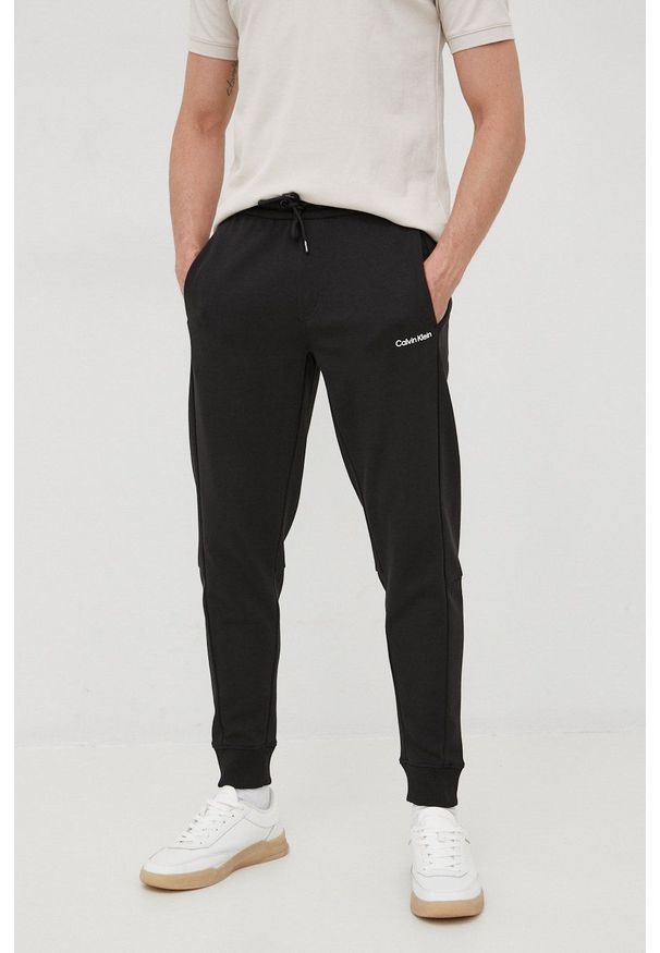 Calvin Klein spodnie męskie kolor czarny gładkie. Kolor: czarny. Wzór: gładki