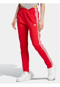 Adidas - adidas Spodnie dresowe adicolor SST IK6603 Czerwony Slim Fit. Kolor: czerwony. Materiał: syntetyk, bawełna