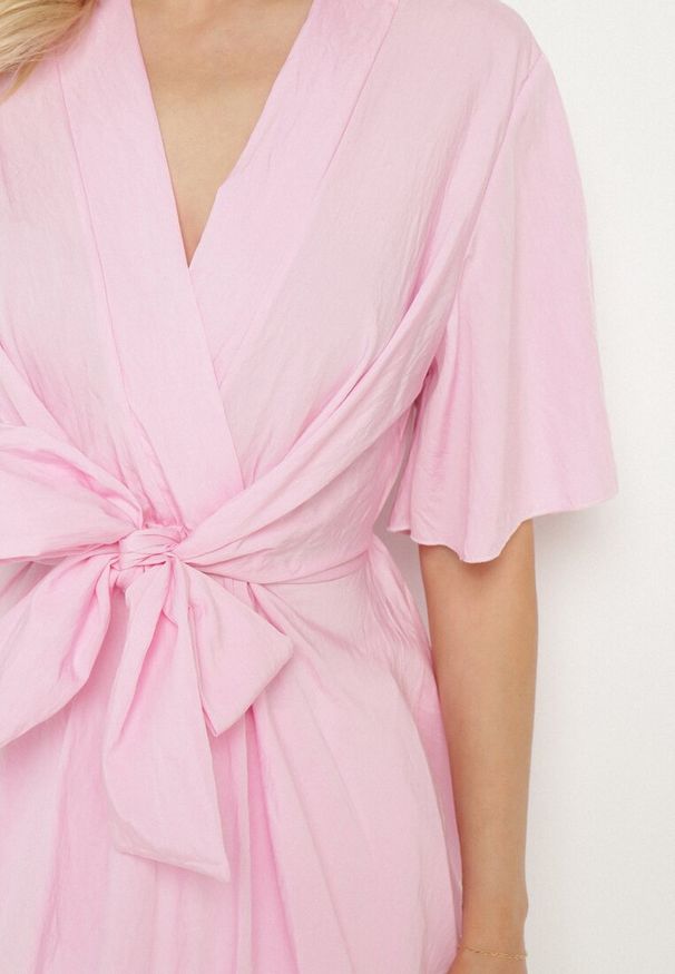 Born2be - Jasnoróżowa Kopertowa Bluzka z Wiskozą Ozdobiona Supłem Tanathria. Okazja: na co dzień. Typ kołnierza: dekolt w serek. Kolor: różowy. Materiał: wiskoza. Długość rękawa: krótki rękaw. Długość: krótkie. Wzór: aplikacja. Styl: casual