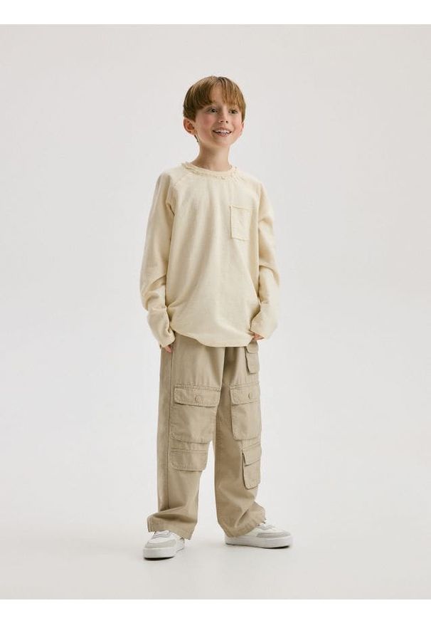 Reserved - Longsleeve oversize z kieszenią - złamana biel. Materiał: dzianina, bawełna. Długość rękawa: długi rękaw