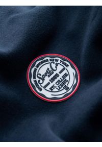 Ombre Clothing - Męska dresowa bluza kangurka z kapturem i naszywką w stylu college – granatowa V2 OM-SSNZ-0144 - XXL. Okazja: na co dzień. Typ kołnierza: kaptur. Kolor: niebieski. Materiał: dresówka. Wzór: aplikacja. Styl: klasyczny, elegancki, sportowy, casual