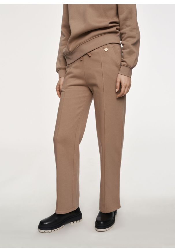 Ochnik - Damskie spodnie dresowe z przeszyciem. Kolor: beżowy. Materiał: bawełna