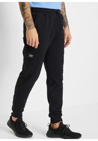bonprix - Spodnie sportowe z kieszeniami cargo, regular fit. Kolor: czarny. Styl: sportowy #1