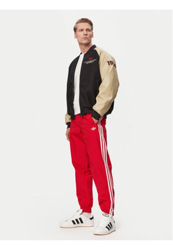 Adidas - adidas Spodnie dresowe Firebird Woven KE1369 Czerwony Regular Fit. Kolor: czerwony. Materiał: syntetyk