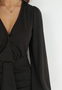 Born2be - Czarna Kopertowa Sukienka z Marszczeniem i Kokardą Marmo. Typ kołnierza: kokarda. Kolor: czarny. Wzór: aplikacja. Typ sukienki: kopertowe. Długość: mini #6