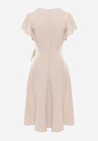 Renee - Beżowa Kopertowa Sukienka z Rozkloszowanym Dołem i Ozdobnym Wiązaniem Dannola. Okazja: na imprezę. Kolor: beżowy. Typ sukienki: kopertowe. Styl: elegancki #3