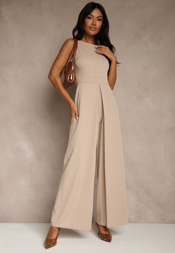 Renee - Beżowy Taliowany Kombinezon Ozdobiony Zakładkami Berinola. Okazja: na imprezę. Kolor: beżowy. Wzór: aplikacja. Styl: elegancki