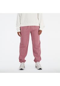 Spodnie damskie New Balance WP41508RSE – różowe. Kolor: różowy. Materiał: bawełna, poliester, materiał, dresówka. Wzór: napisy
