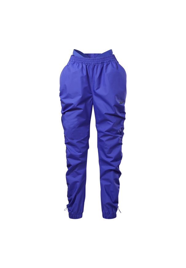 Damskie spodnie dresowe z tkaniny Reebok Cardi B. Kolor: fioletowy. Materiał: tkanina, dresówka. Sport: fitness