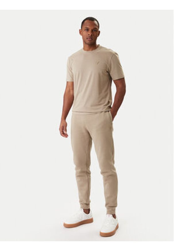 Guess Spodnie dresowe Z2YB22 K9V31 Beżowy Regular Fit. Kolor: beżowy. Materiał: bawełna