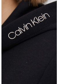 Calvin Klein Bluza damska kolor czarny z kapturem gładka. Okazja: na co dzień. Typ kołnierza: kaptur. Kolor: czarny. Materiał: dzianina. Wzór: gładki. Styl: casual