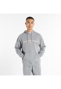 Bluza męska New Balance MT51516YST – szara. Typ kołnierza: kaptur. Kolor: szary. Materiał: bawełna, poliester, dresówka, materiał. Wzór: aplikacja, napisy
