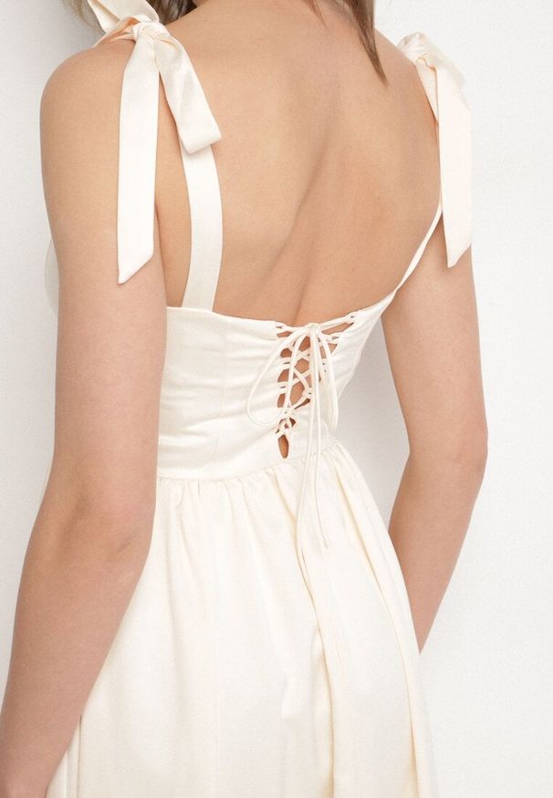 Born2be - Jasnobeżowa Rozkloszowana Sukienka Vices na Wiązanych Ramiączkach Natavine. Okazja: na co dzień, na imprezę. Typ kołnierza: dekolt kwadratowy. Kolor: beżowy. Materiał: poliester, jeans. Długość rękawa: na ramiączkach. Sezon: lato. Styl: casual, klasyczny