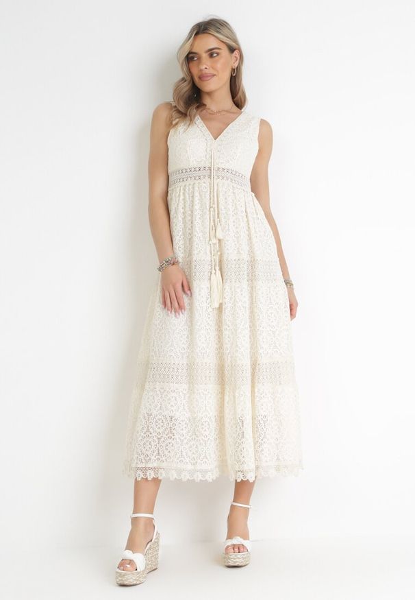 Born2be - Beżowa Koronkowa Sukienka Maxi z Głębokim Dekoltem i Ozdobnym Wiązaniem Nohia. Kolor: beżowy. Materiał: koronka. Długość rękawa: bez rękawów. Wzór: ażurowy. Sezon: wiosna, lato. Długość: maxi