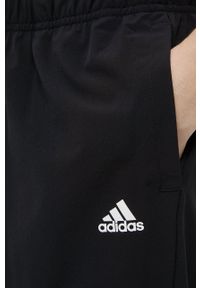 Adidas - adidas spodnie treningowe damskie kolor czarny gładkie. Kolor: czarny. Materiał: skóra, poliester, materiał. Wzór: gładki. Sport: fitness