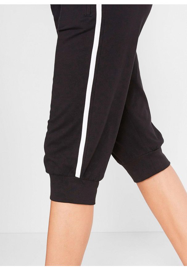 bonprix - Spodnie sportowe 3/4 z bawełny. Kolor: czarny. Materiał: bawełna. Wzór: paski. Styl: sportowy