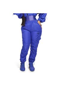 Damskie spodnie dresowe z tkaniny Reebok Cardi B. Kolor: fioletowy. Materiał: tkanina, dresówka. Sport: fitness