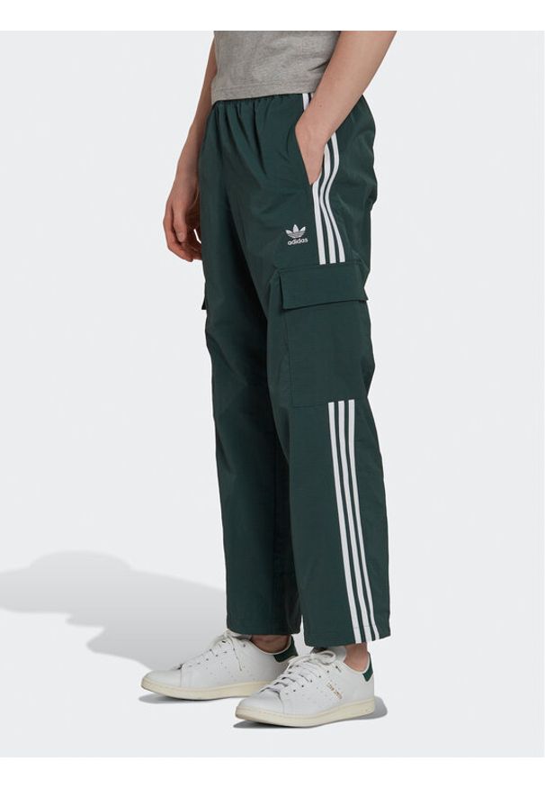 Adidas - adidas Spodnie dresowe adicolor 3 Stripes HN6736 Zielony Relaxed Fit. Kolor: zielony. Materiał: syntetyk, dresówka