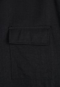 Born2be - Czarna Nietoperzowa Koszula Safari z Bawełną z Wiązaniem w Talii Tierona. Okazja: do pracy, na co dzień, na spotkanie biznesowe. Kolor: czarny. Materiał: bawełna. Długość: długie. Styl: biznesowy, casual #5