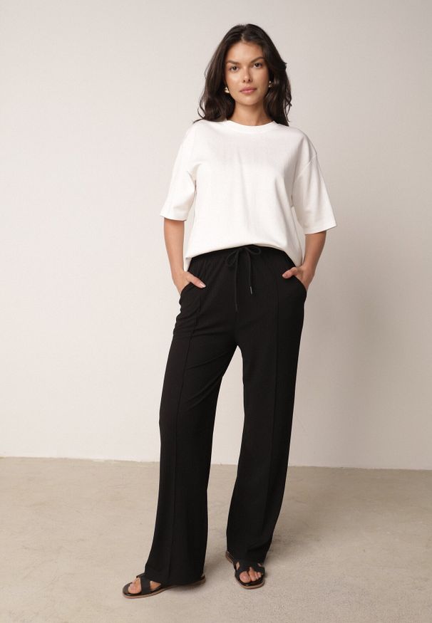 Born2be - Czarne Szerokie Spodnie z Prążkowanej Tkaniny z Wysokim Stanem Sarora. Okazja: na co dzień. Stan: podwyższony. Kolor: czarny. Materiał: tkanina, prążkowany. Wzór: prążki. Styl: casual