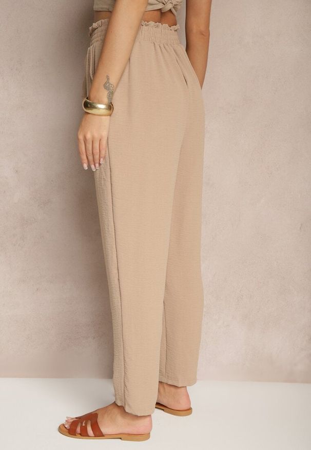 Renee - Ciemnobeżowe Spodnie High Waist Ozdobione Wiązanym Paskiem Araleira. Okazja: na co dzień, na spacer. Stan: podwyższony. Kolor: beżowy. Materiał: jedwab. Długość: długie. Wzór: aplikacja. Sezon: wiosna. Styl: casual