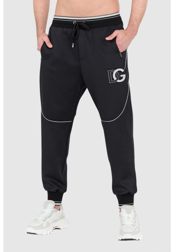 Dolce and Gabbana - DOLCE & GABBANA Czarne spodnie dresowe z dużym logo. Kolor: czarny. Materiał: poliester