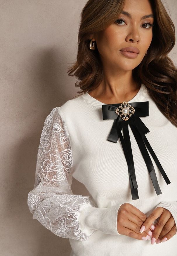 Renee - Biały Sweter ze Wstawkami z Koronki i Kokardką ze Złotą Aplikacją Arfia. Okazja: na co dzień. Typ kołnierza: kokarda. Kolor: biały. Materiał: koronka. Długość rękawa: długi rękaw. Długość: długie. Wzór: koronka, aplikacja. Styl: casual, elegancki