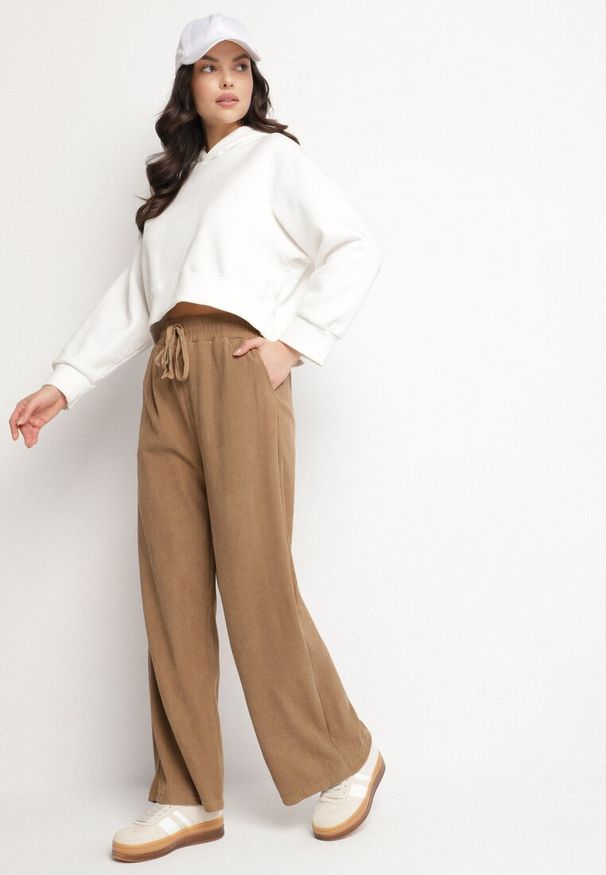 Born2be - Ciemnobeżowe Szerokie Spodnie z Wysokim Stanem Wiązane Sznurkiem Cosetta. Okazja: na co dzień. Stan: podwyższony. Kolor: beżowy. Styl: casual, elegancki