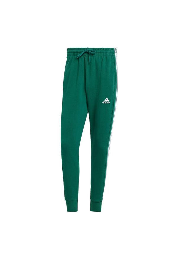 Adidas - Spodnie dresowe męskie adidas Essentials French Terry Tapered Cuff 3-Stripes. Kolor: zielony. Materiał: dresówka