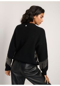 Ochnik - Czarny sweter damski z aplikacją. Kolor: czarny. Materiał: materiał. Długość: długie. Wzór: aplikacja