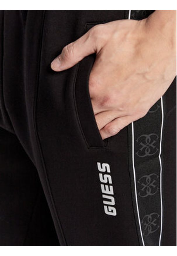 Guess Spodnie dresowe Mickey Z2YB09 KB3P2 Czarny Regular Fit. Kolor: czarny. Materiał: syntetyk, bawełna