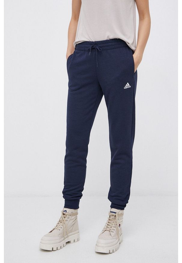 Adidas - adidas Spodnie damskie kolor granatowy gładkie. Kolor: niebieski. Materiał: dzianina, poliester, bawełna. Wzór: gładki