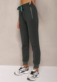 Renee - Ciemnozielone Spodnie Dresowe z Bawełny High Waist Ozdobione Kieszeniami na Suwak Fedela. Okazja: na co dzień. Stan: podwyższony. Kolor: zielony. Materiał: bawełna, dresówka. Długość: długie. Wzór: aplikacja. Styl: casual, elegancki