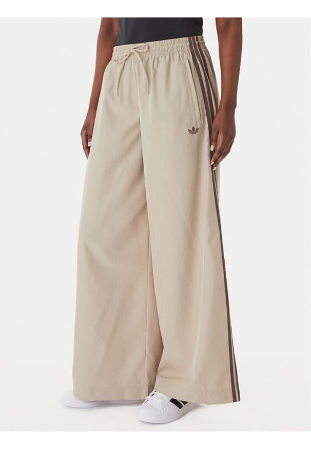 Adidas - adidas Spodnie dresowe Firebird Adilenium KD6300 Beżowy Regular Fit. Kolor: beżowy. Materiał: syntetyk