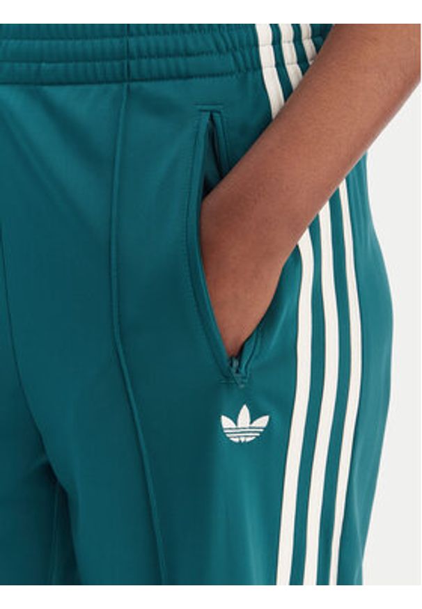 Adidas - adidas Spodnie dresowe Firebird KG3701 Zielony Loose Fit. Kolor: zielony. Materiał: syntetyk