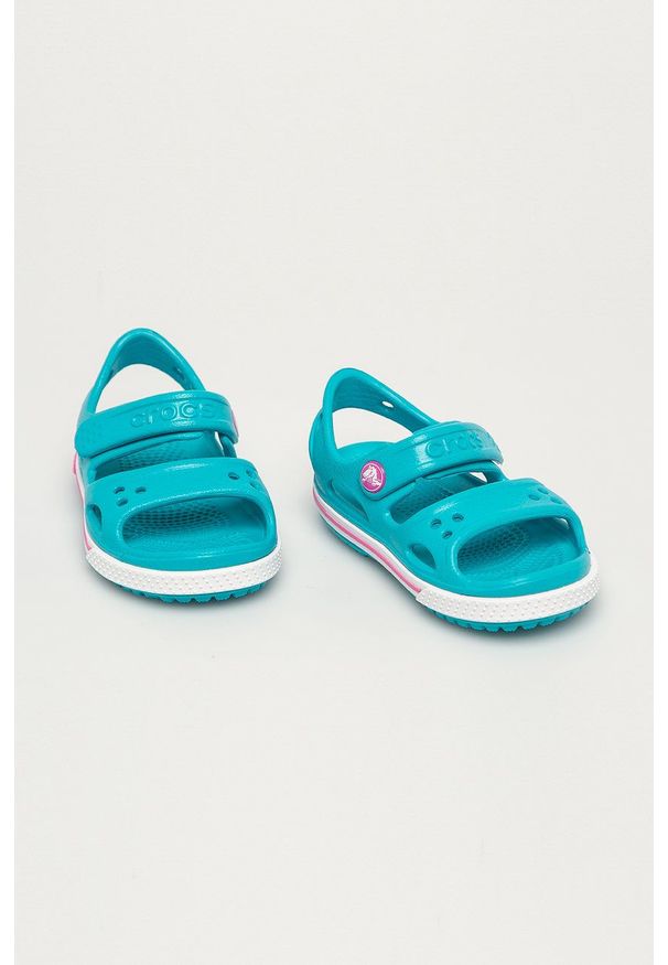 Crocs - Sandały dziecięce. Zapięcie: rzepy. Kolor: turkusowy. Materiał: guma, materiał. Wzór: gładki. Obcas: na obcasie. Wysokość obcasa: niski