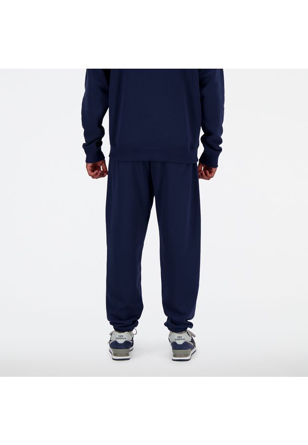 Spodnie męskie New Balance MP41519NNY – granatowe. Kolor: niebieski. Materiał: dresówka, poliester, bawełna. Wzór: haft