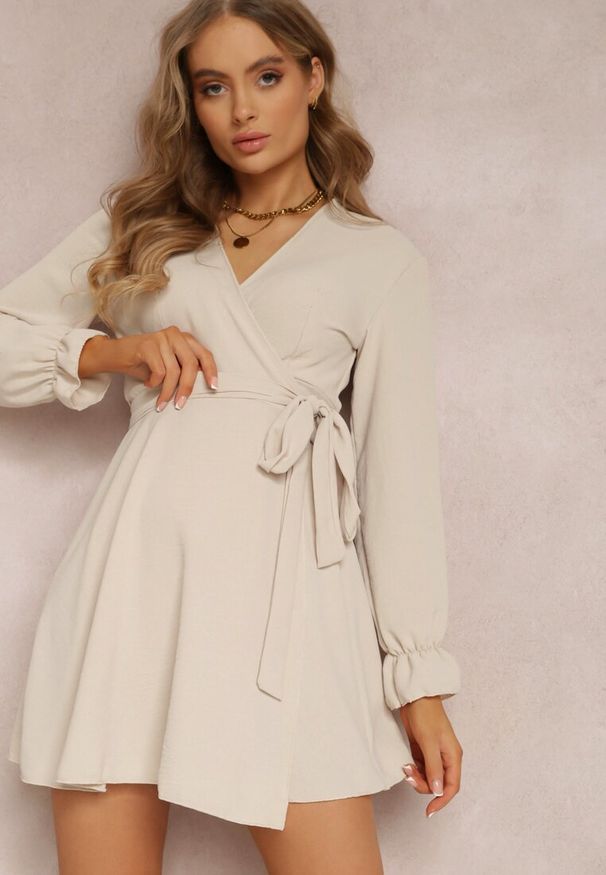 Renee - Jasnobeżowa Sukienka Parthameia. Kolor: beżowy. Materiał: tkanina. Wzór: jednolity. Typ sukienki: kopertowe. Styl: klasyczny. Długość: mini